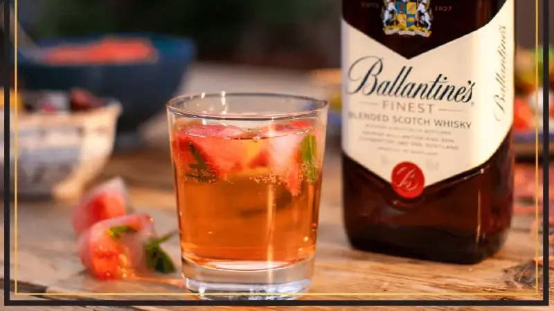 01 cốc rượu Ballantines kèm chai rượu Ballantines đặt trên bàn