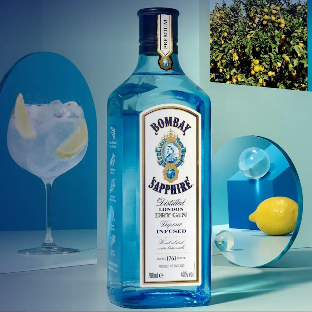 Chai rượu Bombay Sapphire đặt trên mặt phẳng, đằng sau là gương và ảnh trang trí